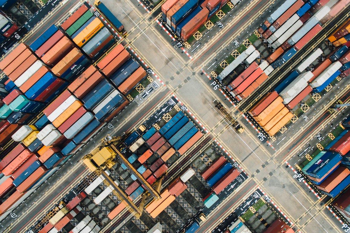 Vista aérea de contenedores y vías de transporte en un terminal de carga